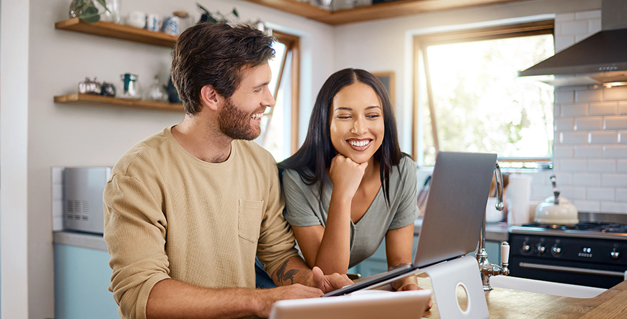 couple on laptop in sunny kitchen